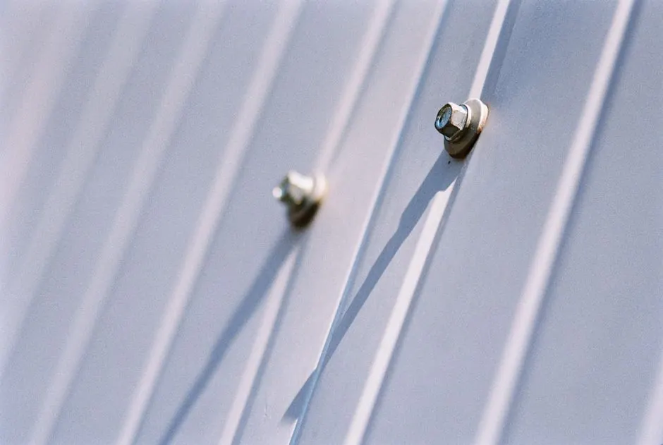 Detailed view of metal screws securing a steel sheet, highlighting durability.